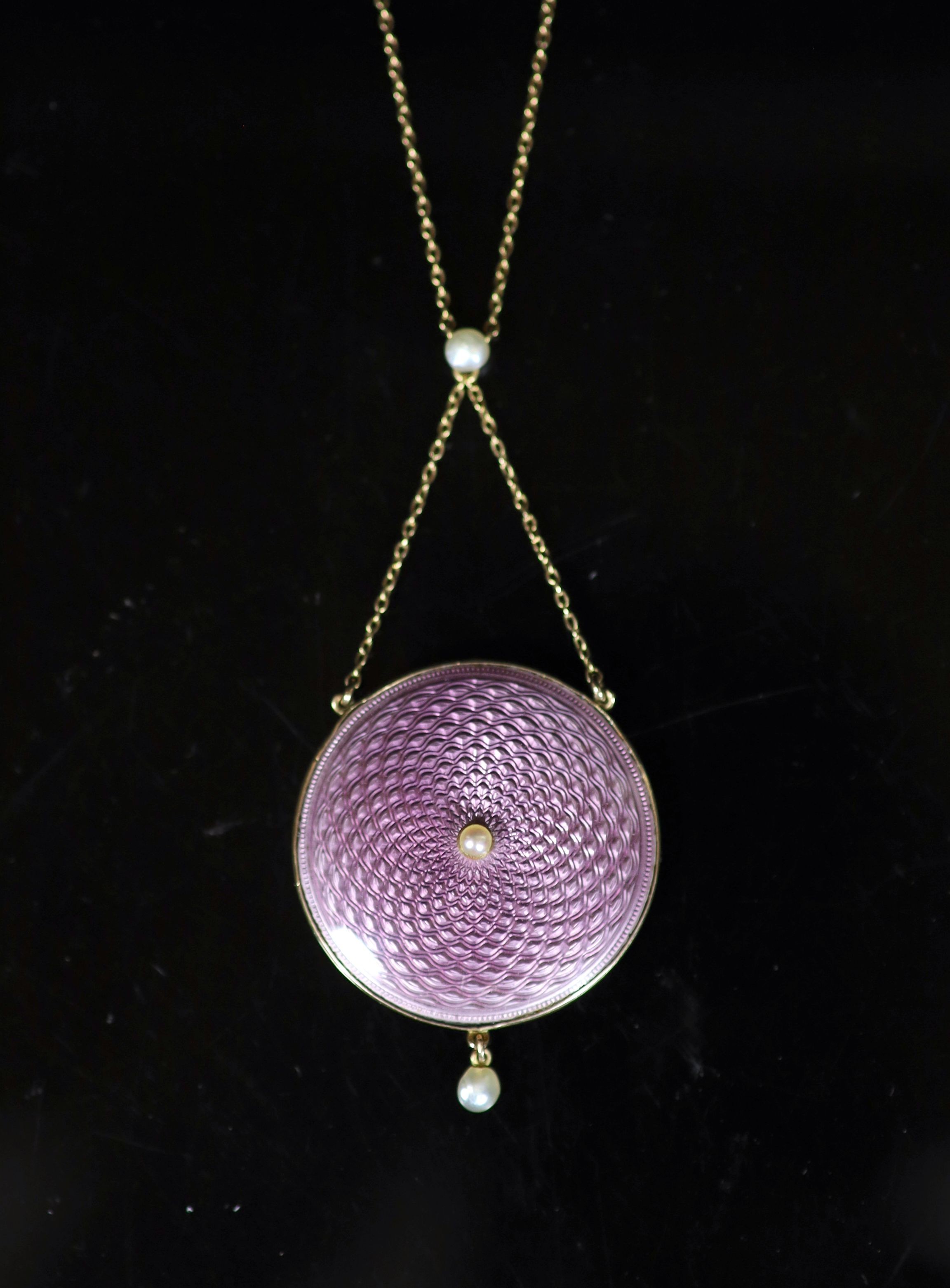 An Edwardian gold, pink guilloche enamel and seed pearl set drop circular pendant necklace